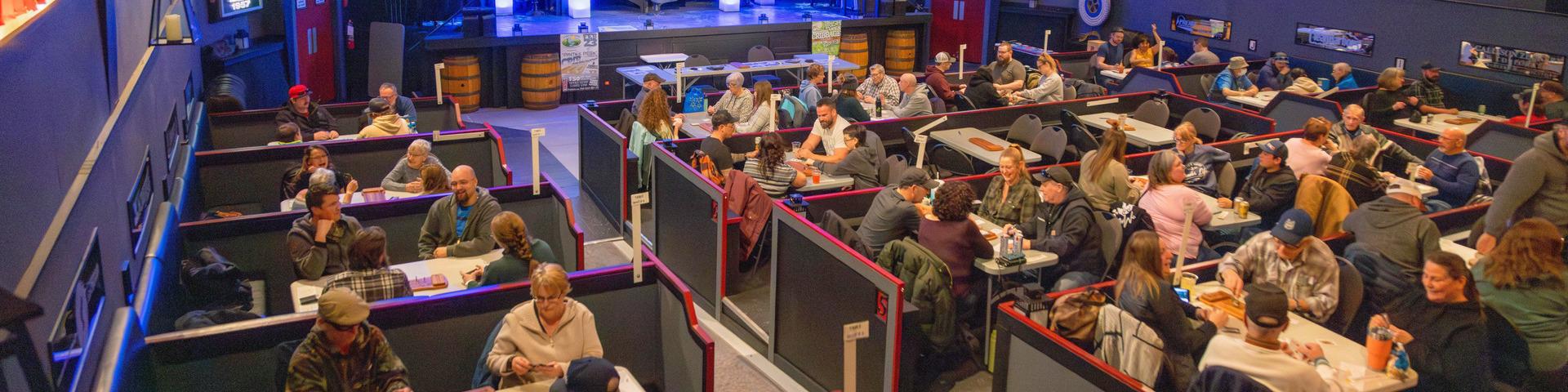 Dozens of people play in a card tournament at a local establishment.